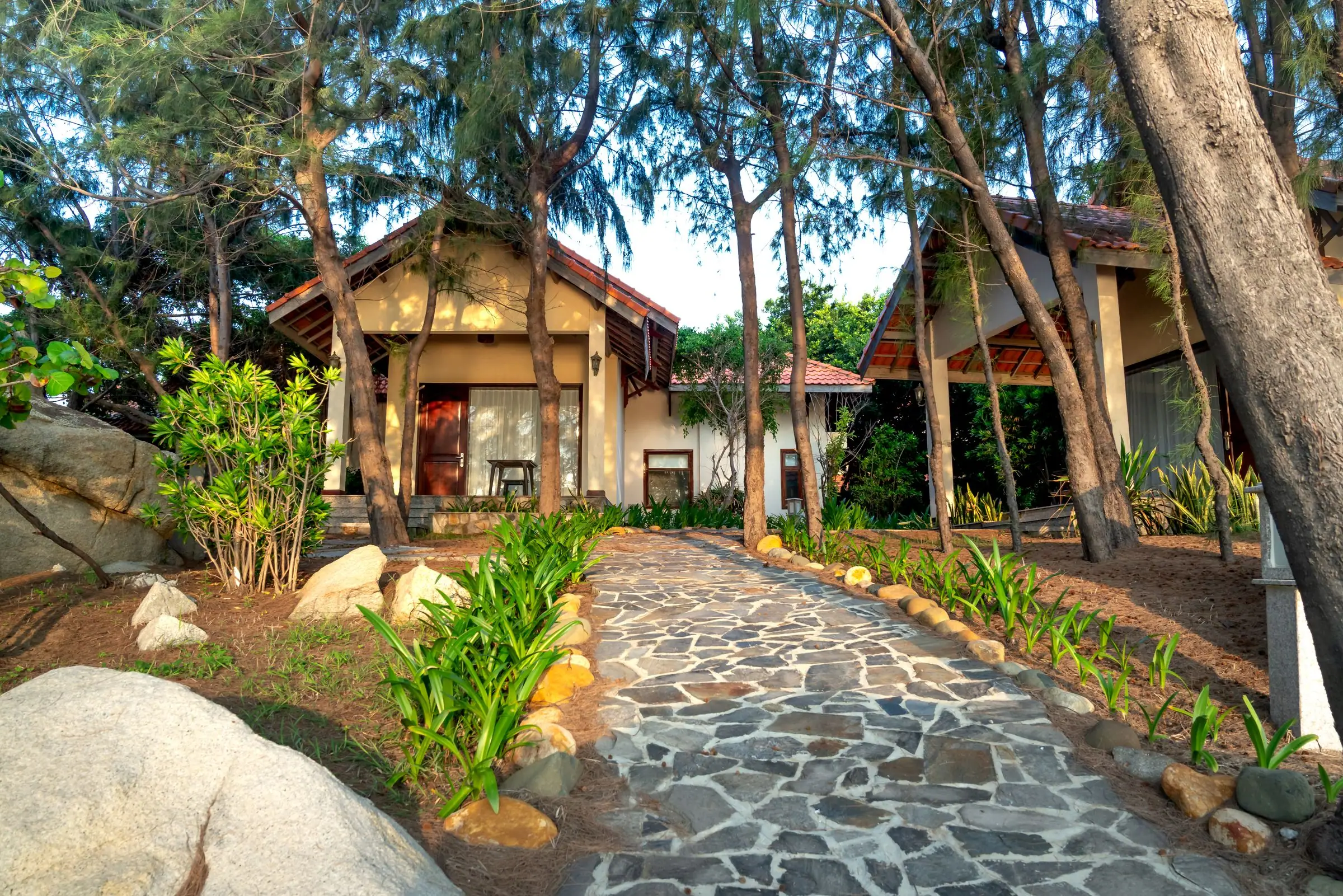 Stone path through a tropical garden to a house