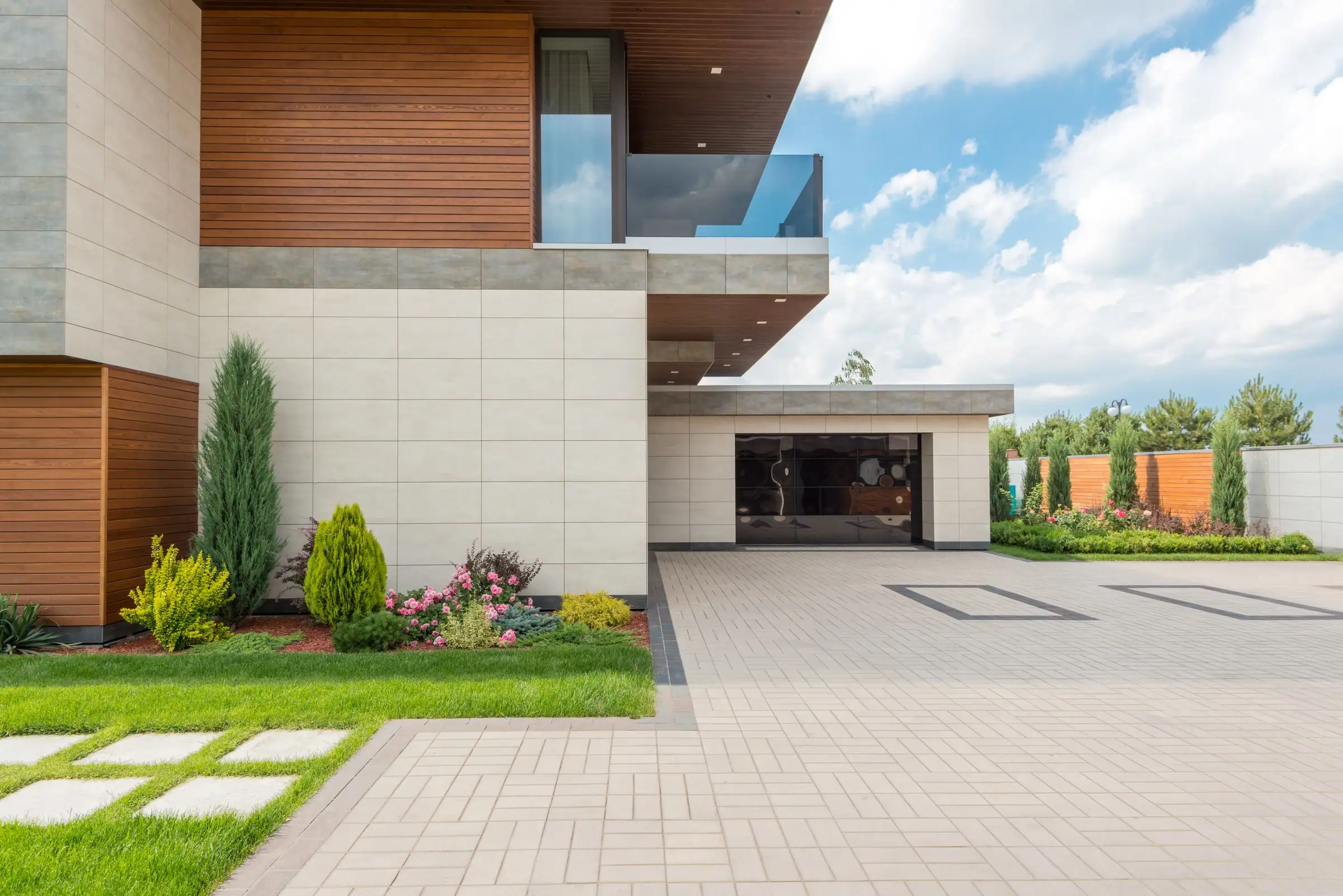 Modern house with a light paver driveway and lawn steps