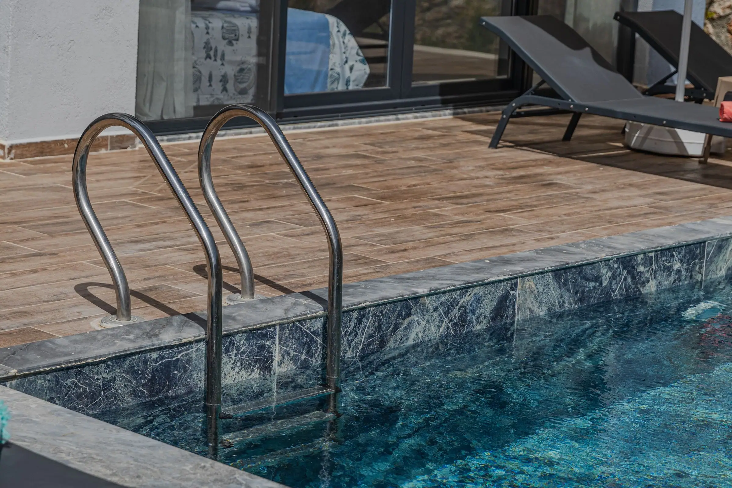 Pool ladder and coping where the deck meets the water