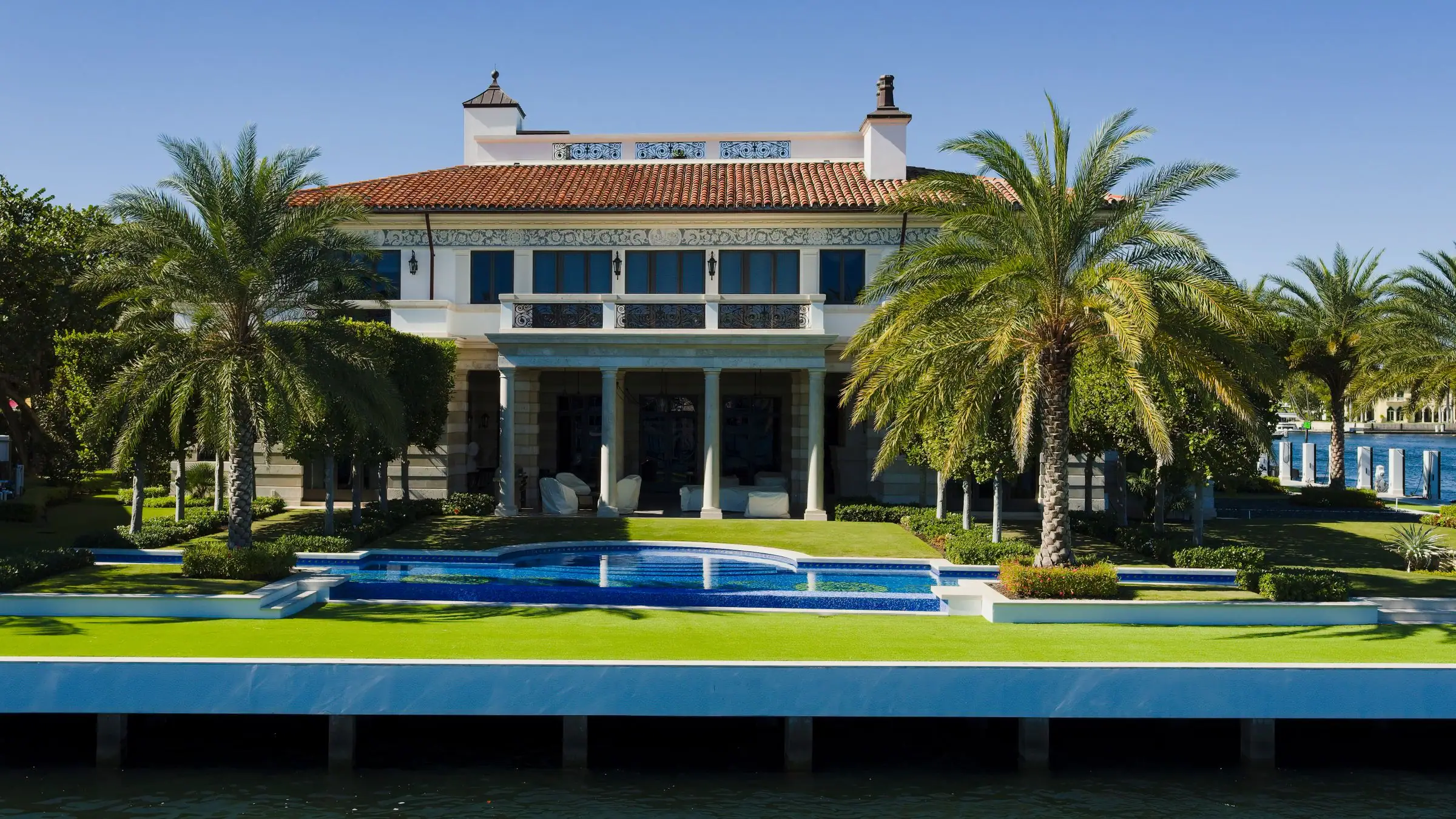 Home with a pool and tropical garden beside the water